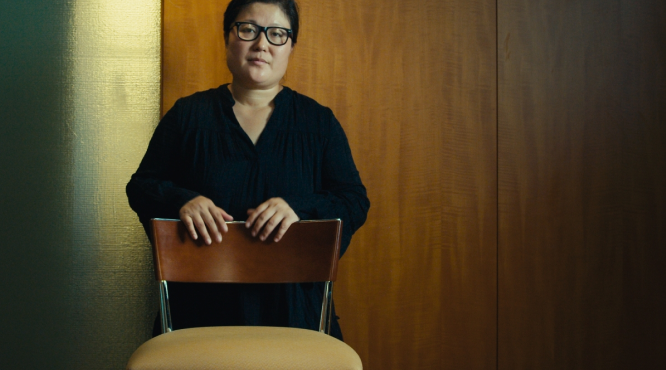 Woman standing behind chair