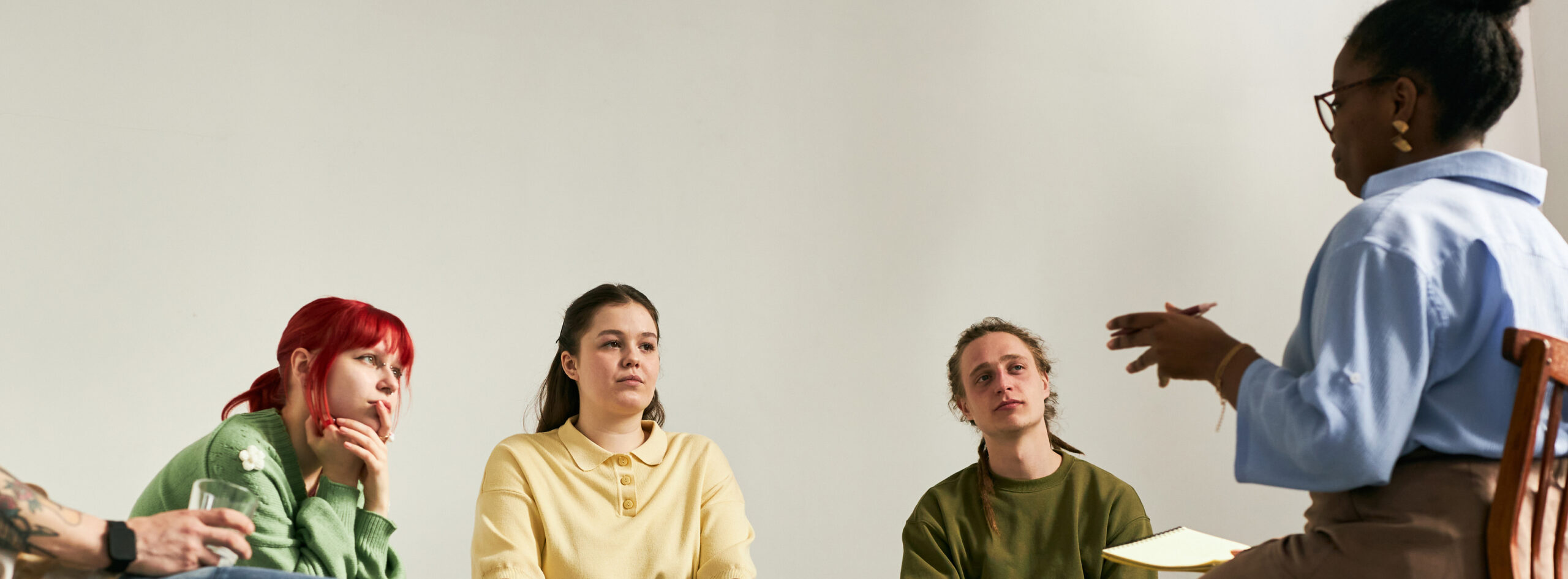 Engaging in Group Therapy Session with Diverse Participants Man standing behind a chair