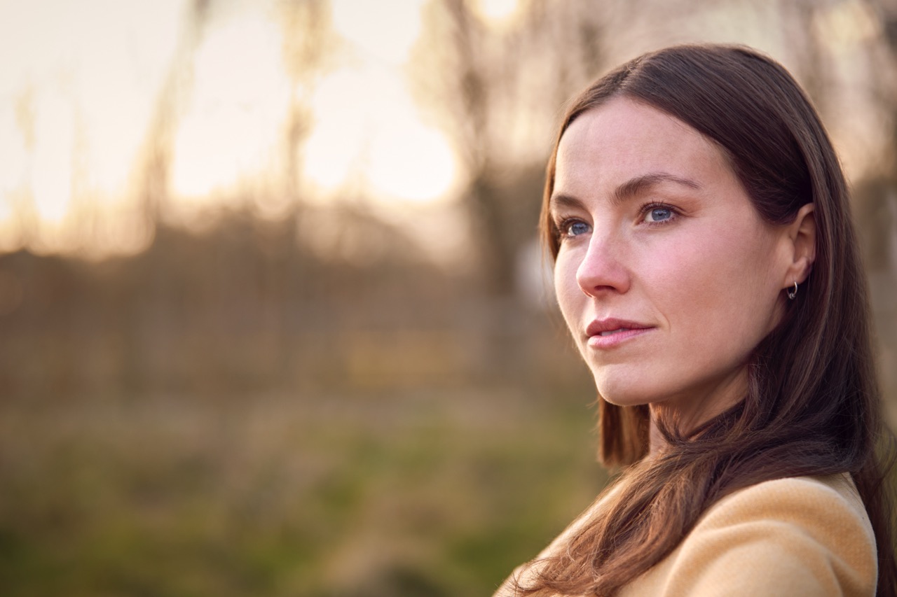 Head And Shoulders Portrait Of Woman On Walk Through Autumn Or Winter Countryside